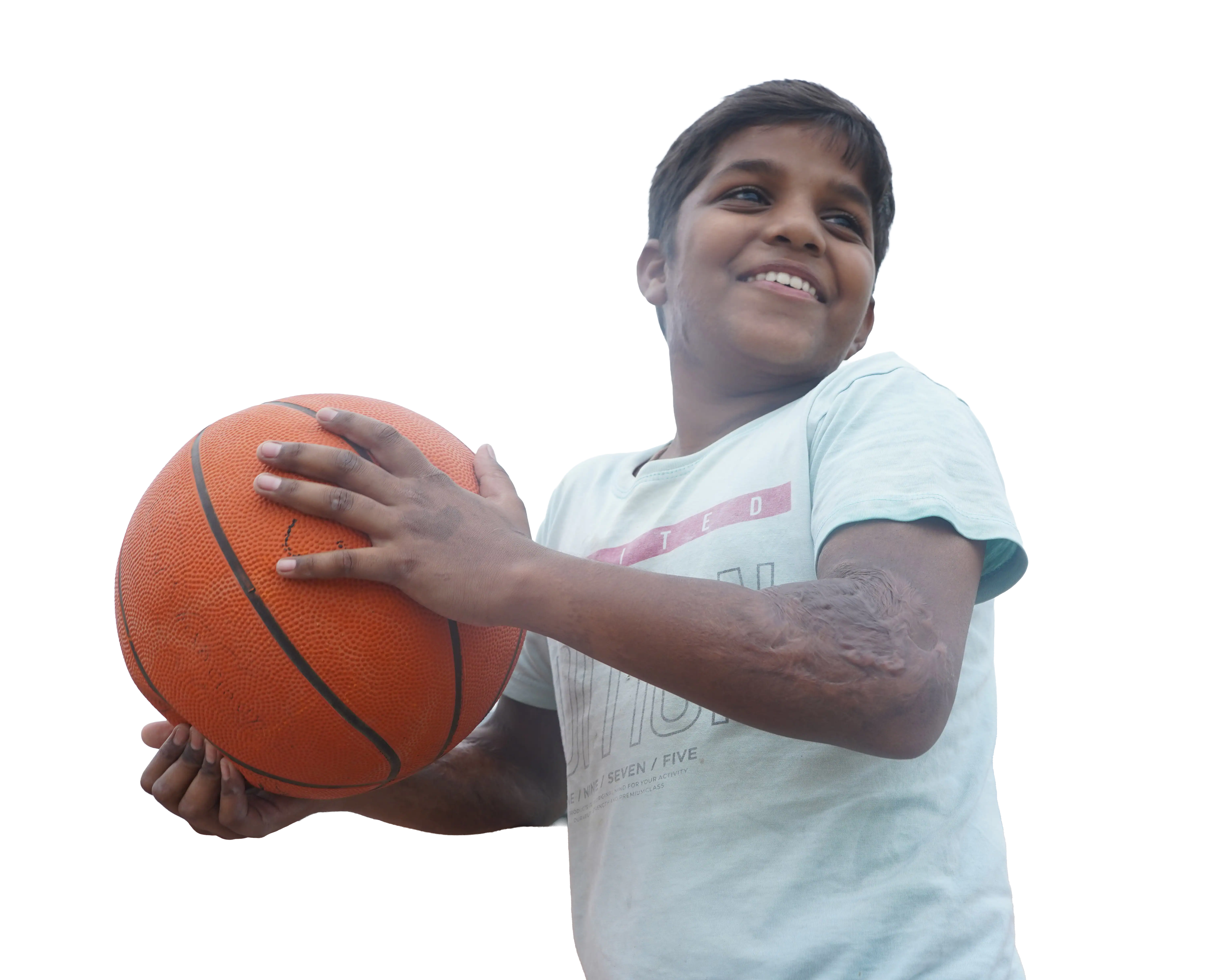 Young boy smiling and holding a basketball